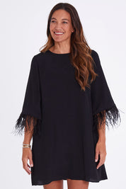 Model Alex wearing size 10 of the Enchanted Feather Sleeve Dress in colour Black (Black), from the front, cropped image
