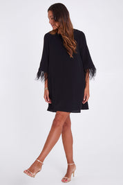 Model Alex wearing size 10 of the Enchanted Feather Sleeve Dress in colour Black (Black), from the front, showing the whole outfit