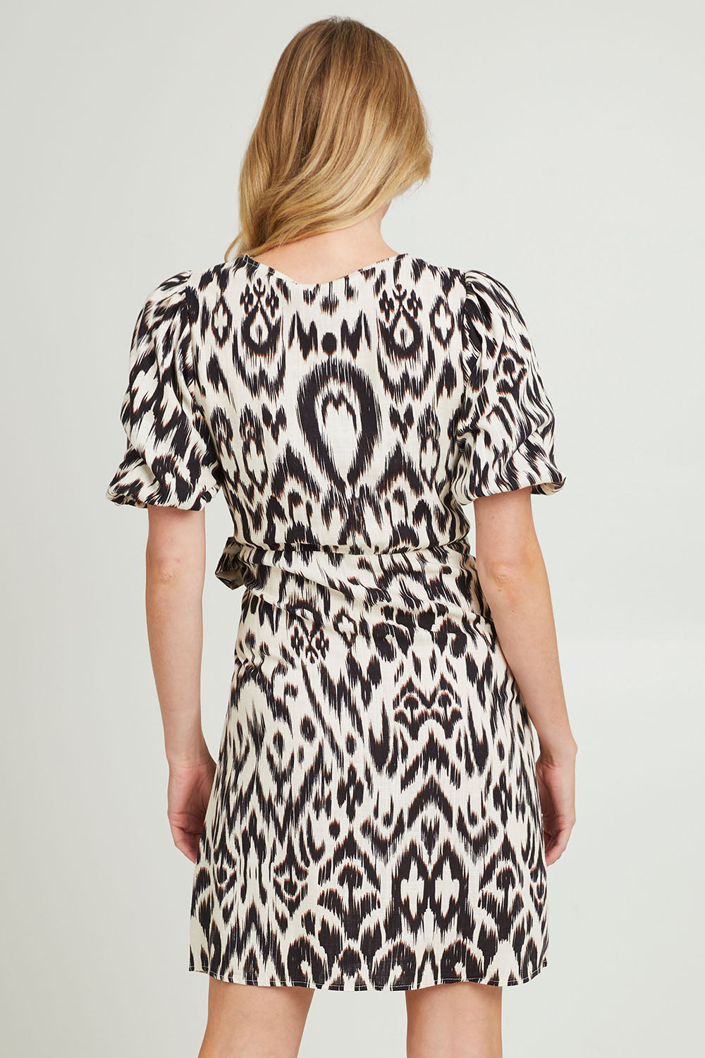 Model Grace wearing size 10 of the Paradise Wrap Dress in colour Animal (Black), from the back