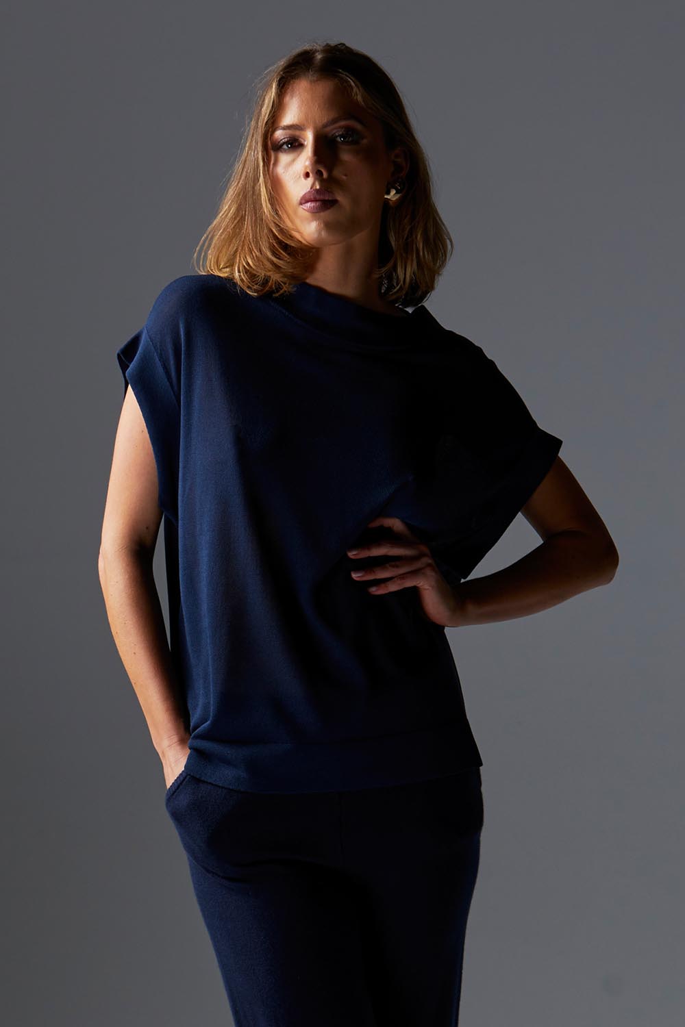 A model wearing the Junos Knit in colour Navy (Blue), from the front, showing the whole outfit