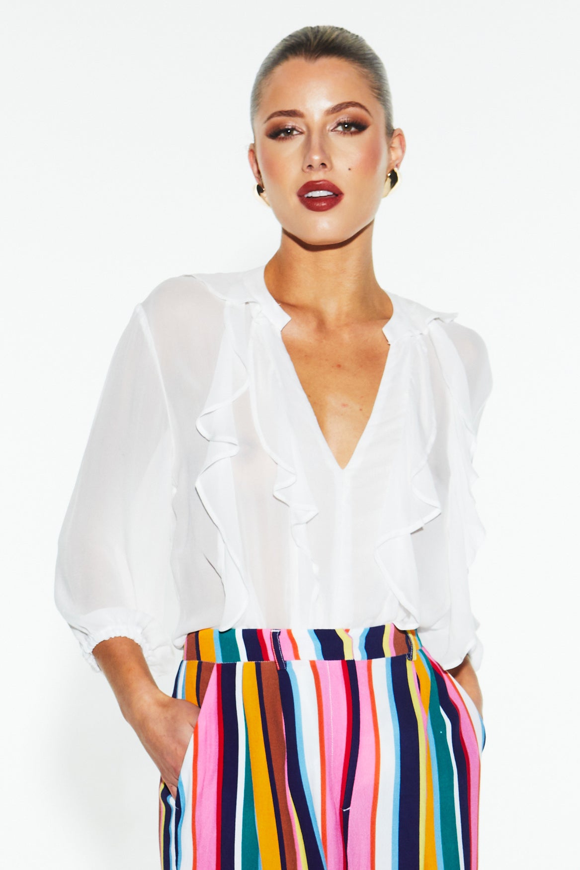A model wearing the Just Love Ruffle Blouse in colour White (White), from the front, cropped image
