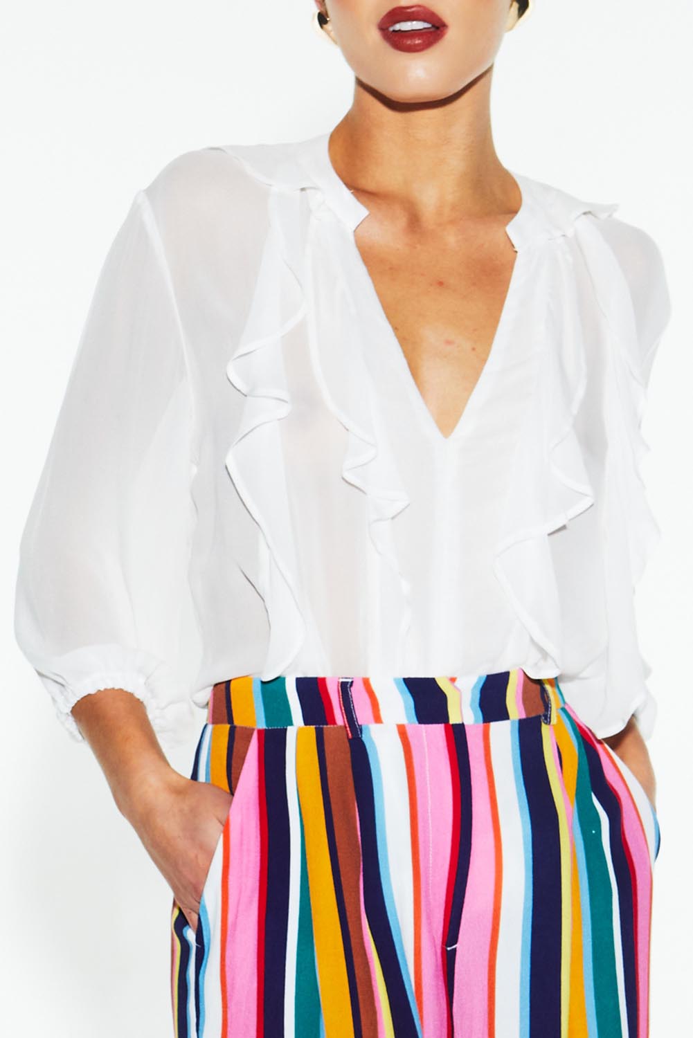 A model wearing the Just Love Ruffle Blouse in colour White (White), from the front, cropped image