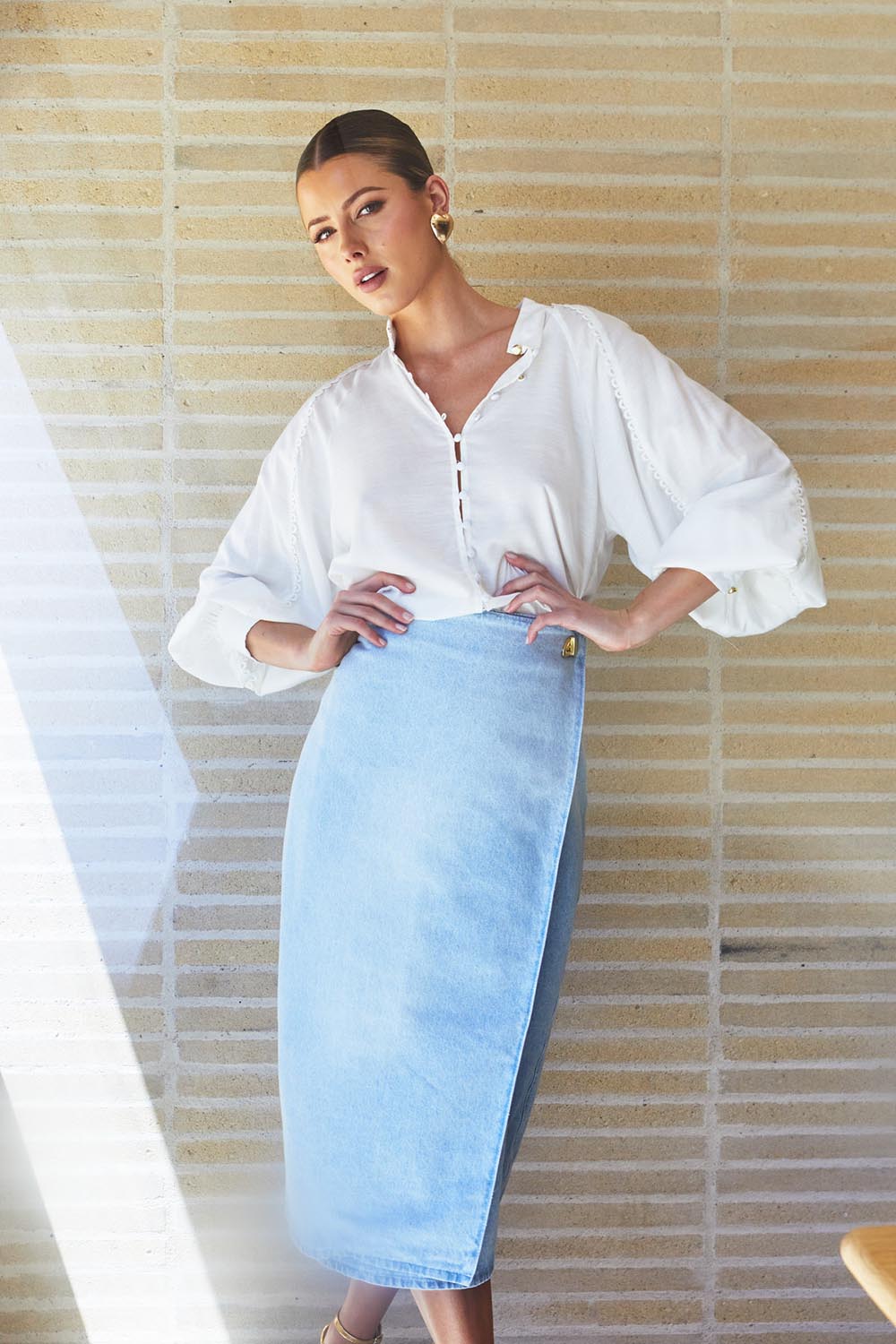 A model wearing the Flight Denim Wrap Skirt in colour Wash (Blue), from the front, showing the whole outfit