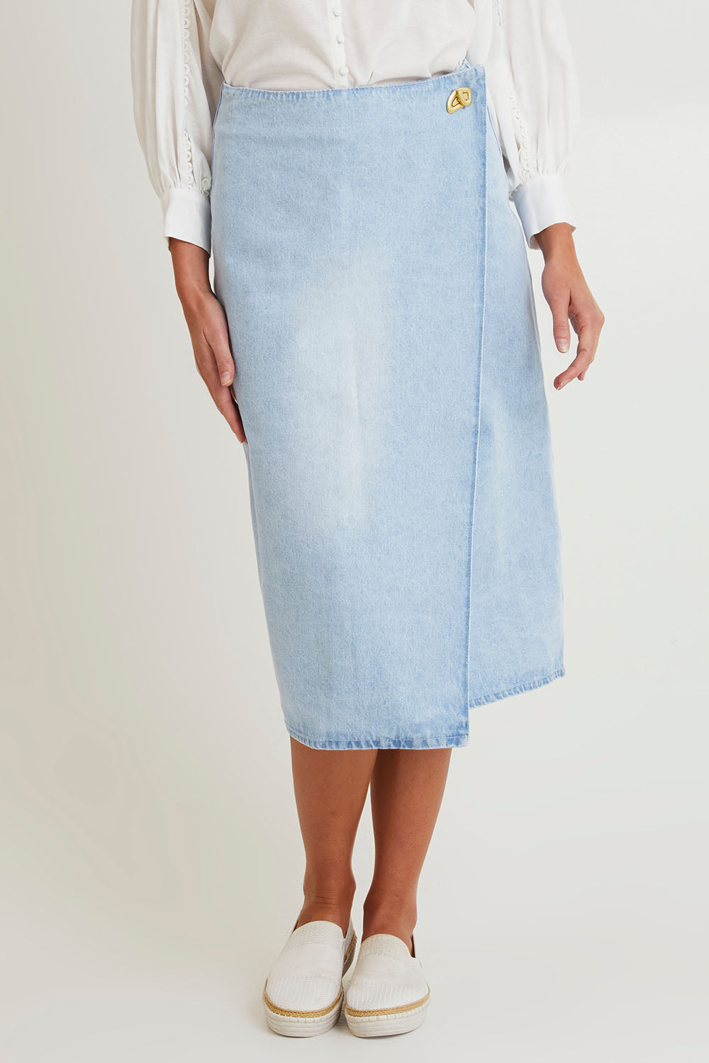 Model Madeline wearing size 10 of the Flight Denim Wrap Skirt in colour Wash (Blue), from the front, cropped image