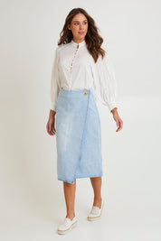Model Madeline wearing size 10 of the Flight Denim Wrap Skirt in colour Wash (Blue), from the front, showing the whole outfit
