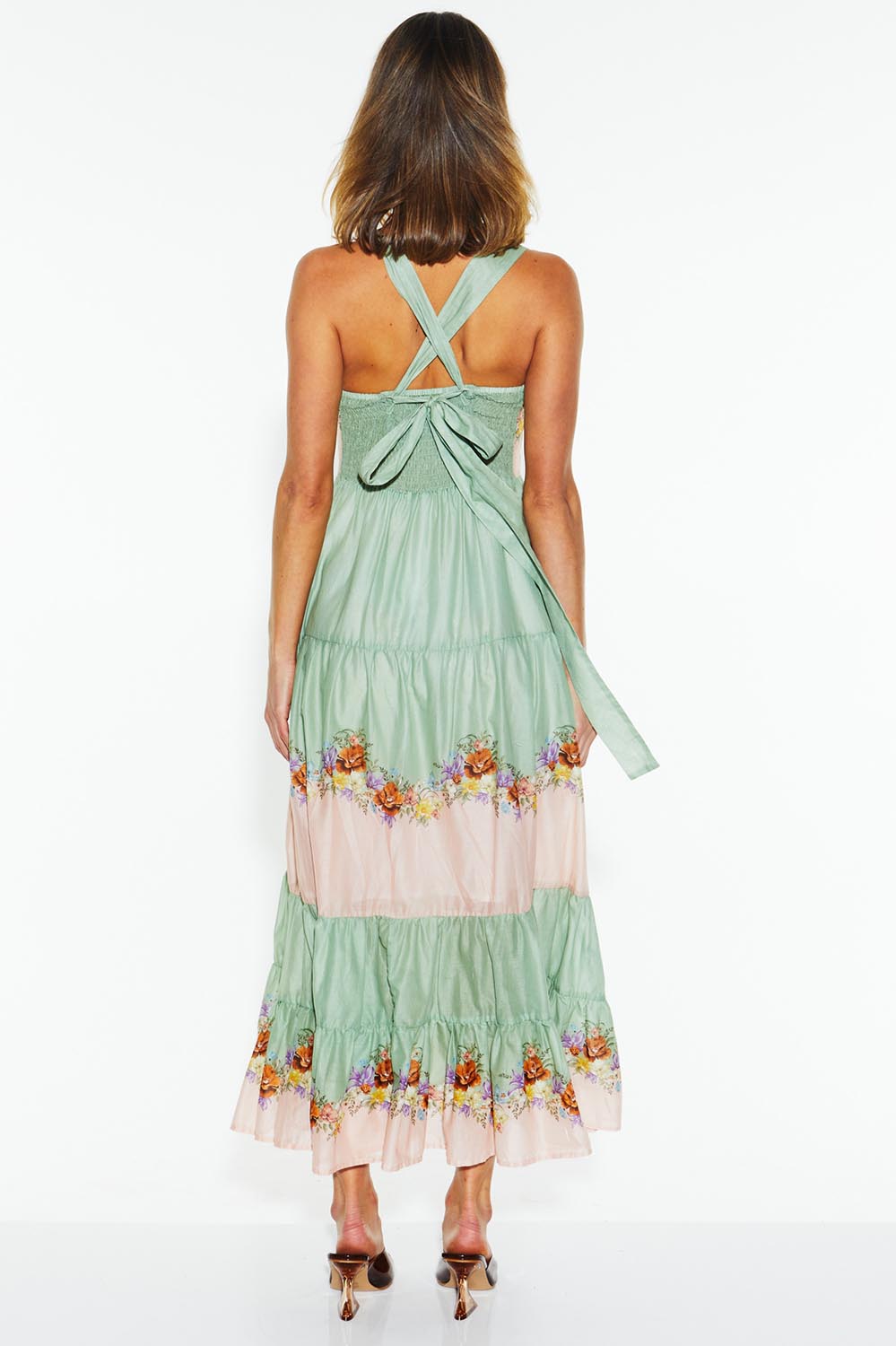 A model wearing the Hollyhock Cotton Voile Maxi Dress in colour Floraleye (Green), from the back