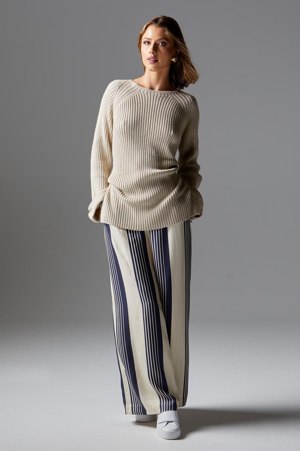 A model wearing the Heartstopper Pant in colour Navystripe (Blue), from the front, showing the whole outfit