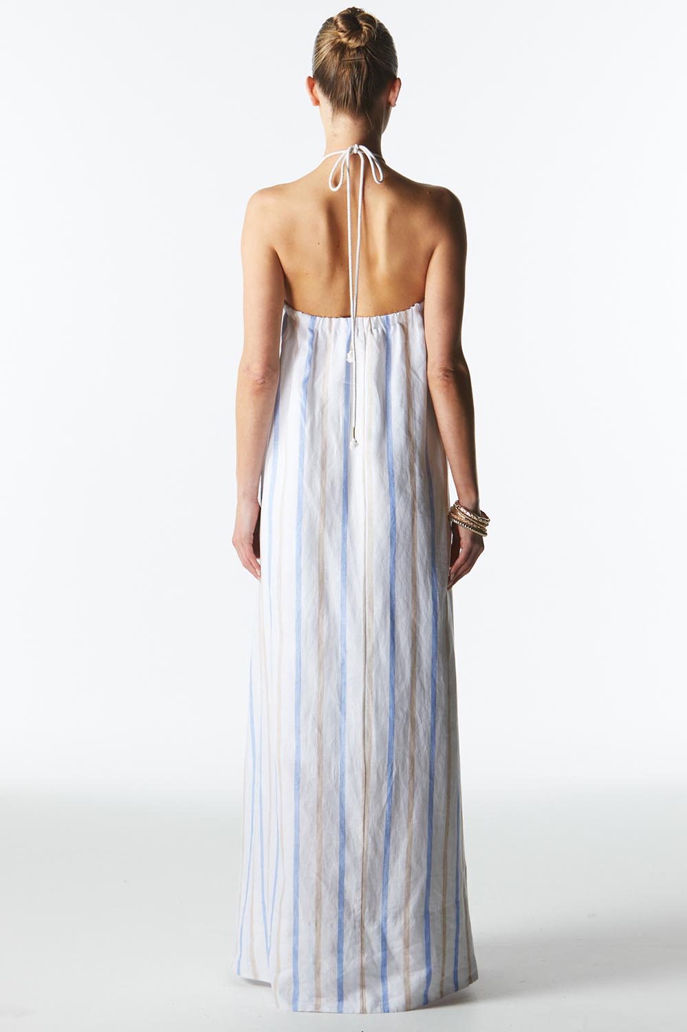 A model wearing the Poolside Boxy Linen Dress in colour Stripe (Blue), from the back
