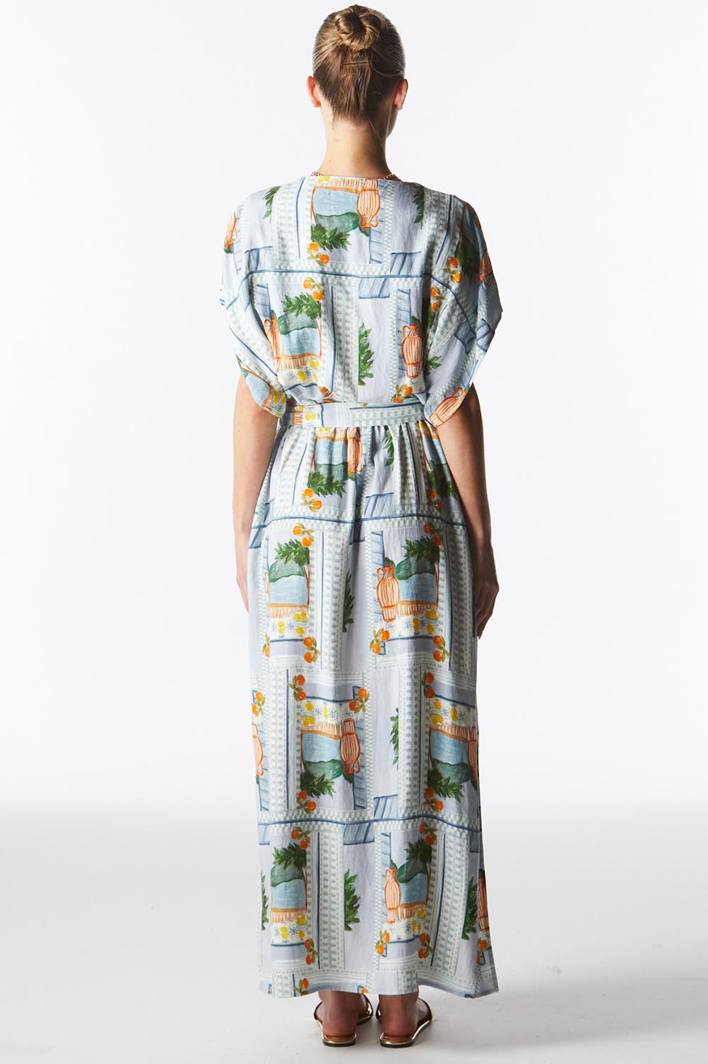 A model wearing The Terrace Linen Cotton Dress in colour Postcard (Blue), from the back
