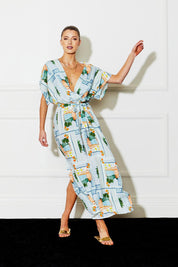 A model wearing The Terrace Linen Cotton Dress in colour Postcard (Blue), from the front, showing the whole outfit
