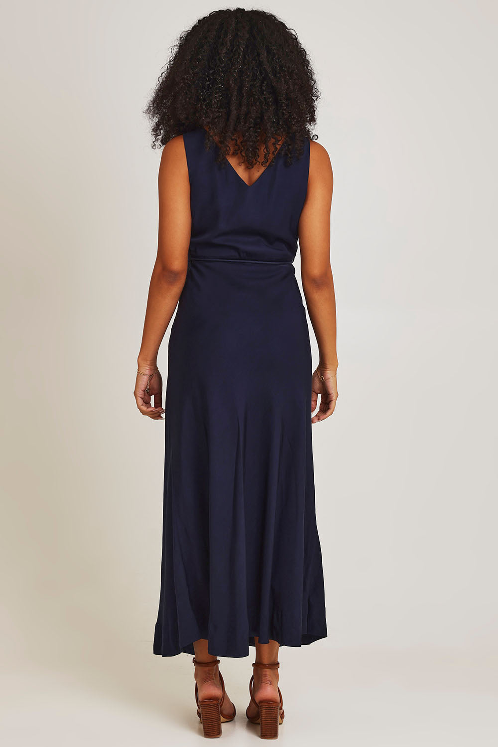Model Ziara wearing size 10 of the Fusion Dress in colour Navy (Blue), from the back