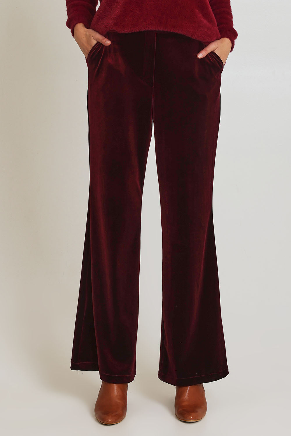 Model Madeline wearing size 10 of the Mustang Sally Velvet Pant in colour Wine (Red), from the front, cropped image