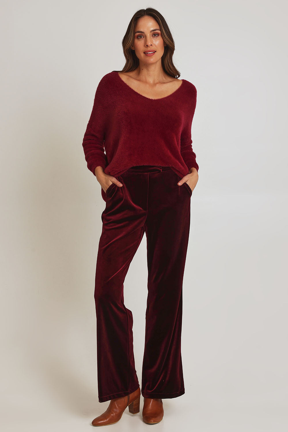 Model Madeline wearing size 10 of the Mustang Sally Velvet Pant in colour Wine (Red), from the front, showing the whole outfit