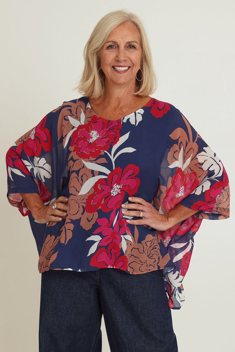 Model Sandy wearing size 10 of the Magnetic Fever Top in colour Pinkfloral (Blue), from the front, cropped image