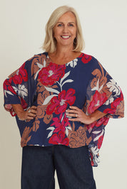 Model Sandy wearing size 10 of the Magnetic Fever Top in colour Pinkfloral (Blue), from the front, cropped image