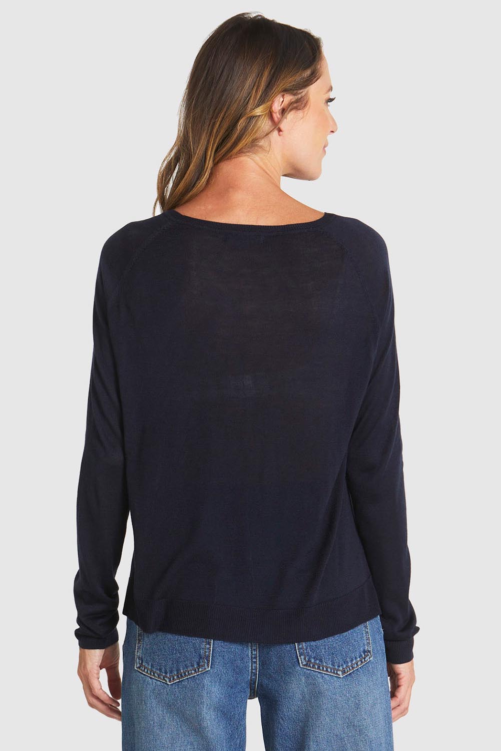 A model wearing the Reminiscent Knit Top in colour Navy (Blue), from the back