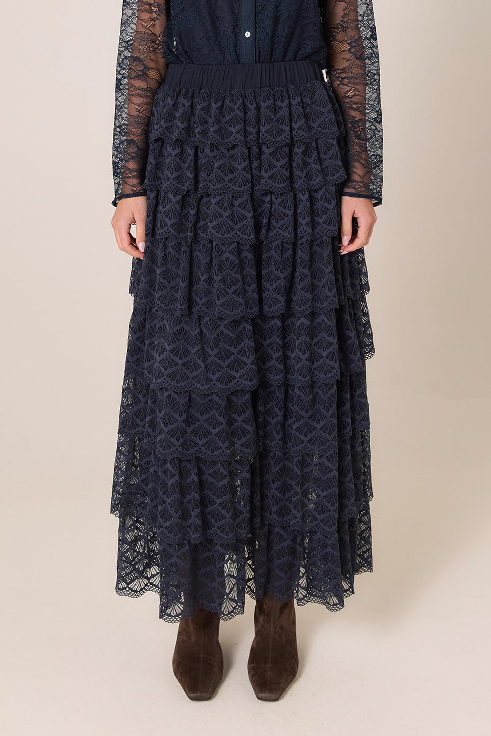 A model wearing the Domino Maxi Skirt in colour Navy (Blue), from the front, cropped image