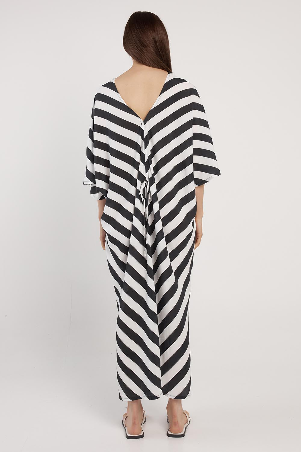A model wearing the Madeira Dress in colour Liquorice (Black), from the back