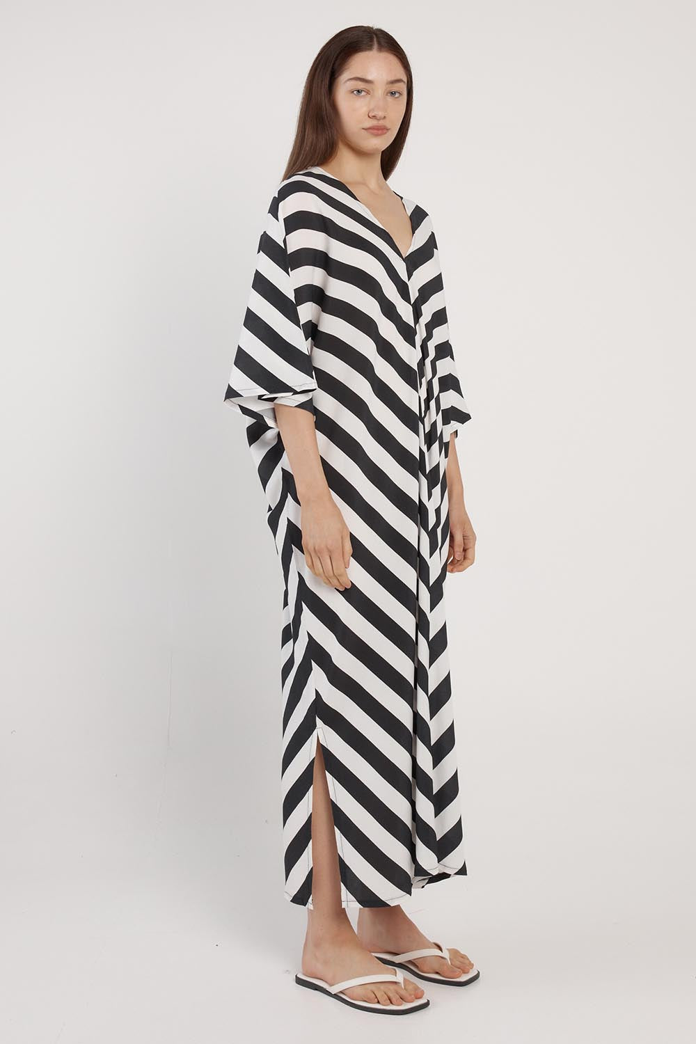 A model wearing the Madeira Dress in colour Liquorice (Black), from the front, showing the whole outfit