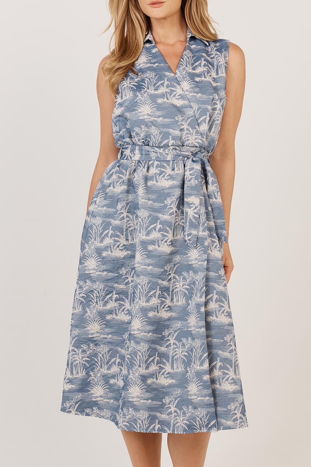 A model wearing the Zanzabar Dress in colour Bluereed (Blue), from the front, cropped image