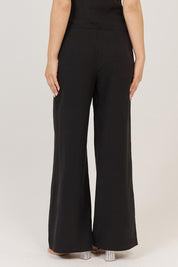A model wearing the Sandara Pant in colour Black (Black), from the back