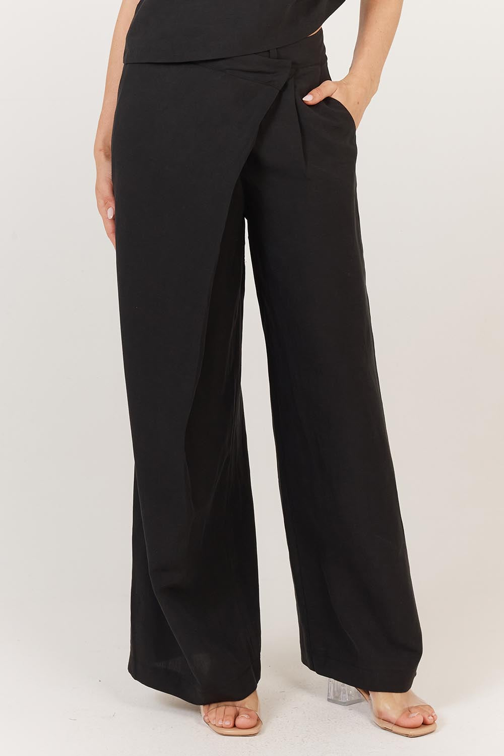 A model wearing the Sandara Pant in colour Black (Black), from the front, cropped image
