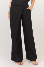A model wearing the Sandara Pant in colour Black (Black), from the front, cropped image