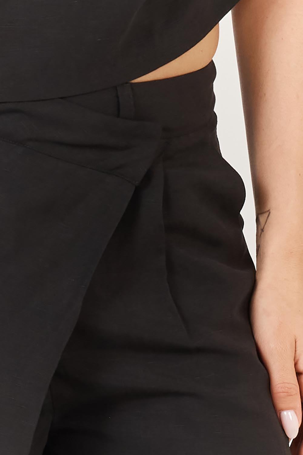 A model wearing the Sandara Pant in colour Black (Black), from the front, cropped image