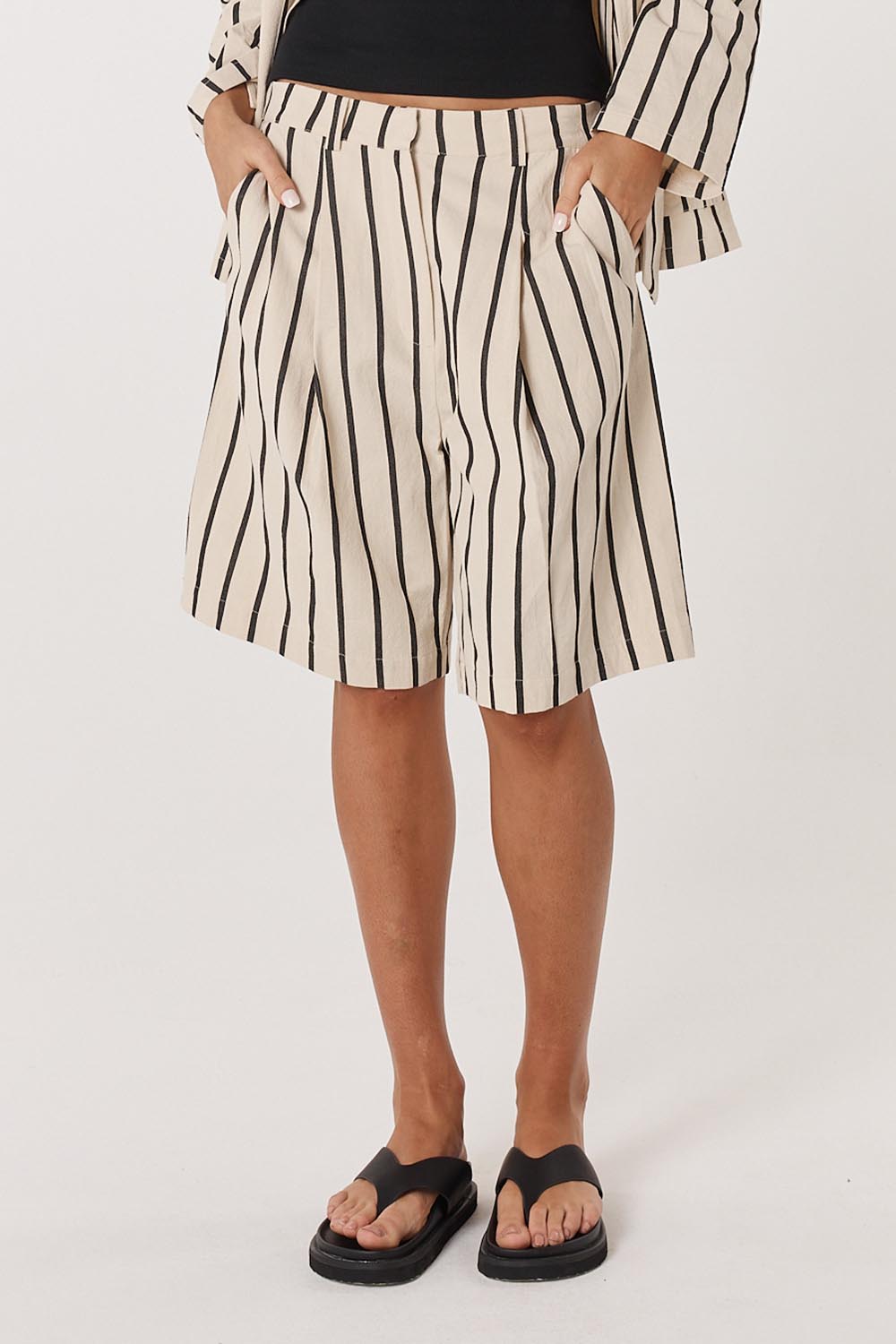 A model wearing the Luna Cotton Blend Bermuda Short in colour Creamblack, from the front, cropped image