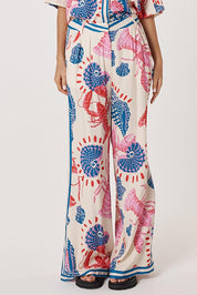 A model wearing the Soleil Pant in colour Lobster, from the front, cropped image