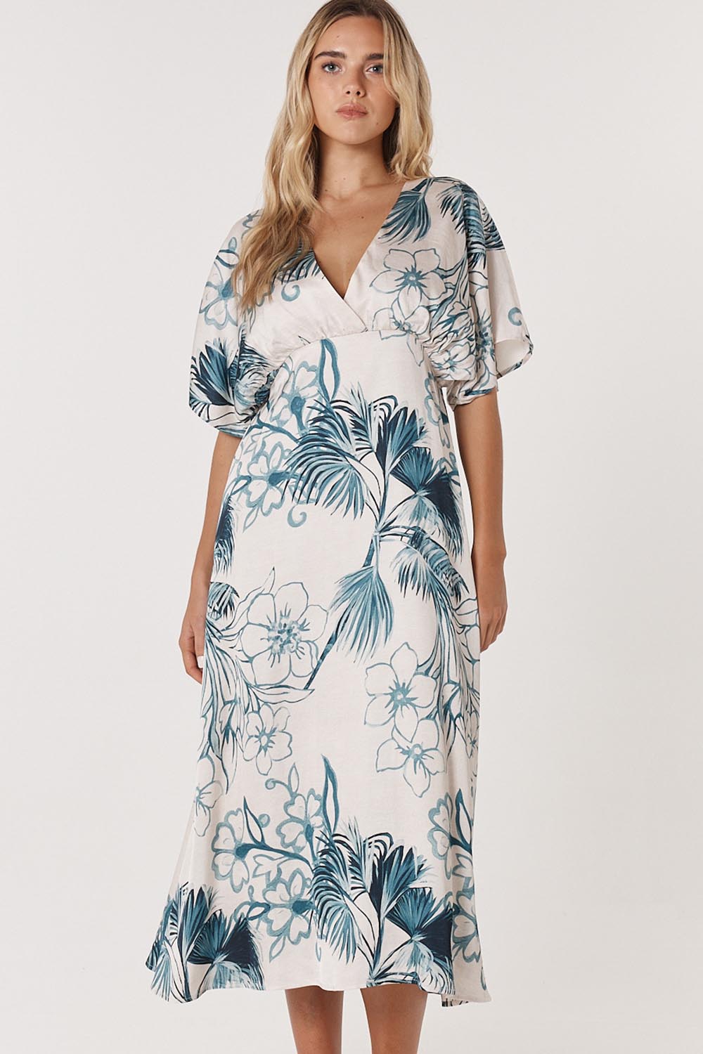 A model wearing the Solstice Palms Midi Dress in colour Palm (Blue), from the front, cropped image