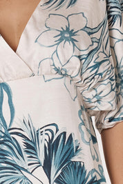 A model wearing the Solstice Palms Midi Dress in colour Palm (Blue), from the front, cropped image