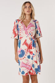A model wearing the Soleil Wrap Dress in colour Lobster, from the front, cropped image