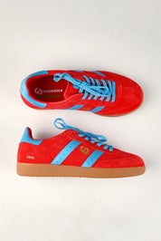 A model wearing size 37 of the 2001 Parallel Suede Sneaker in colour Melonblue (Red), from the front, showing the whole outfit