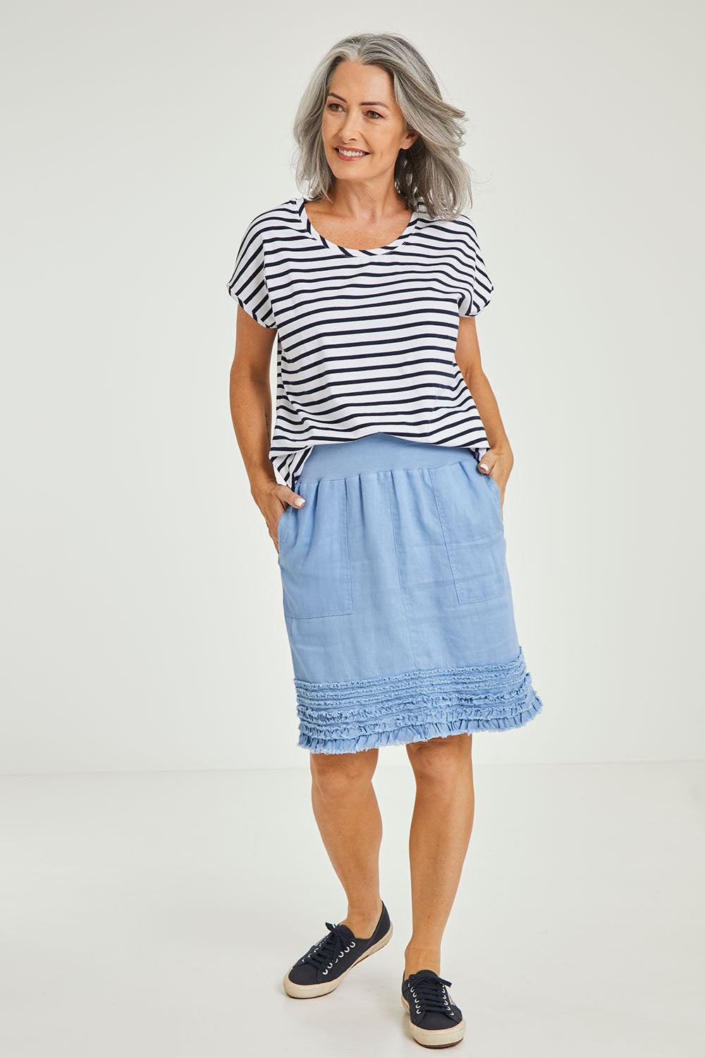 Model Luisa wearing size 10 of the Frill Hem Pull On Linen Skirt in colour Denim (Blue), from the front, showing the whole outfit