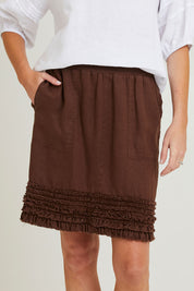 Model Grace wearing size 10 of the Frill Hem Pull On Linen Skirt in colour Koko, from the front, cropped image