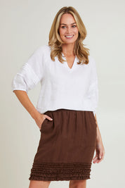 Model Grace wearing size 10 of the Frill Hem Pull On Linen Skirt in colour Koko, from the front, cropped image