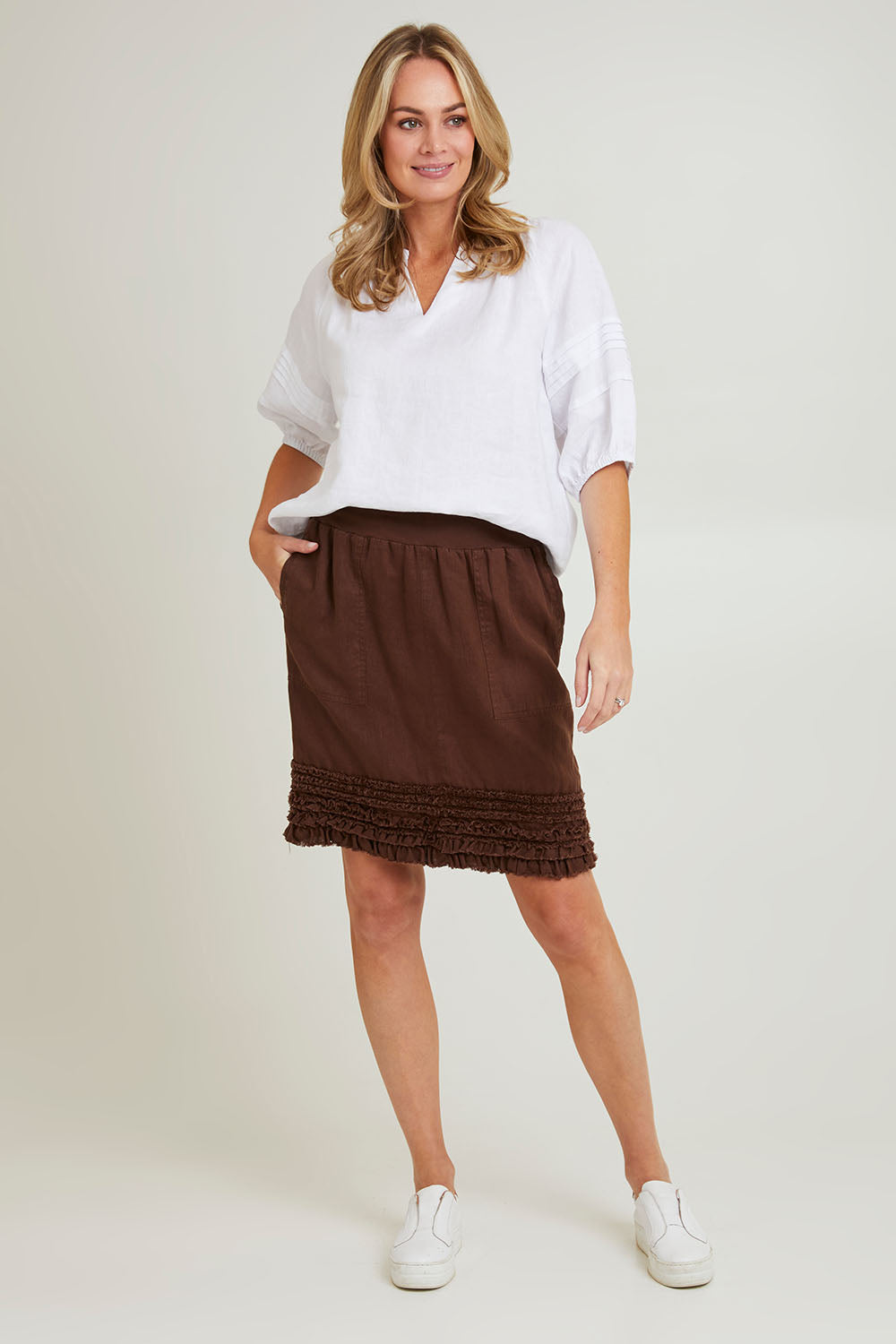 Model Grace wearing size 10 of the Frill Hem Pull On Linen Skirt in colour Koko, from the front, showing the whole outfit