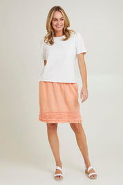 Model Grace wearing size 10 of the Frill Hem Pull On Linen Skirt in colour Mandarine, from the front, showing the whole outfit