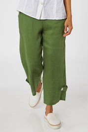 Model Cara wearing size 10 of the Side Button Pant in colour Green (Green), from the front, cropped image