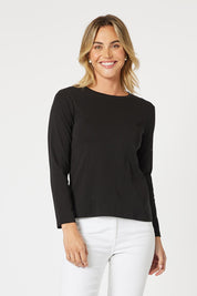 A model wearing the Crew Neck Long Sleeve Cotton Top in colour Black (Black), from the front, cropped image