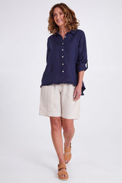 Model Emma wearing size 10 of the Ruffle Hem Linen Shirt in colour Navy (Blue), from the front, showing the whole outfit