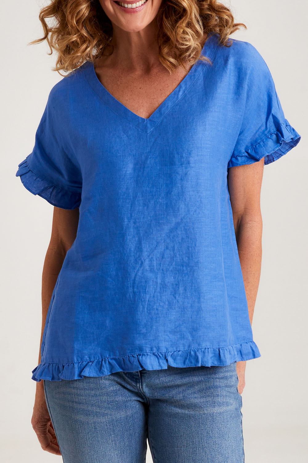 Model Emma wearing size 10 of the Alex Ruffle Linen Top in colour Cobalt (Blue), from the front, cropped image