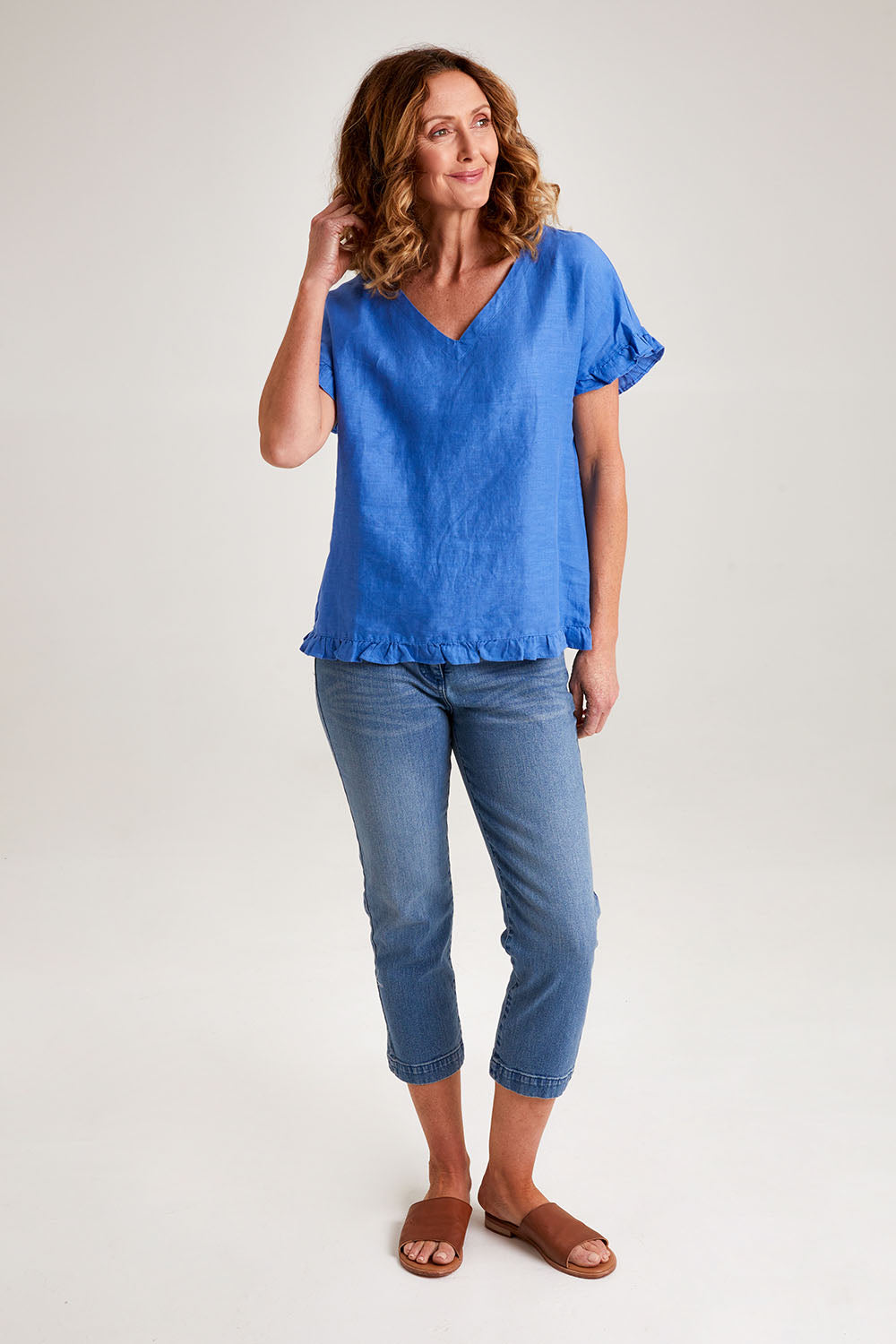 Model Emma wearing size 10 of the Alex Ruffle Linen Top in colour Cobalt (Blue), from the front, showing the whole outfit