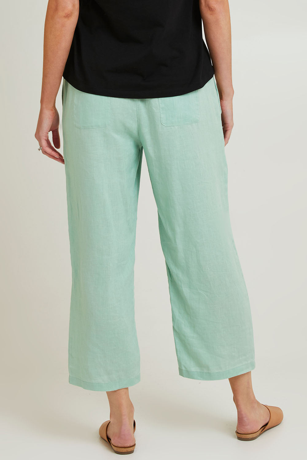 Model Grace wearing size 10 of the Classic Wide Leg Linen Pant in colour Mint (Green), from the back