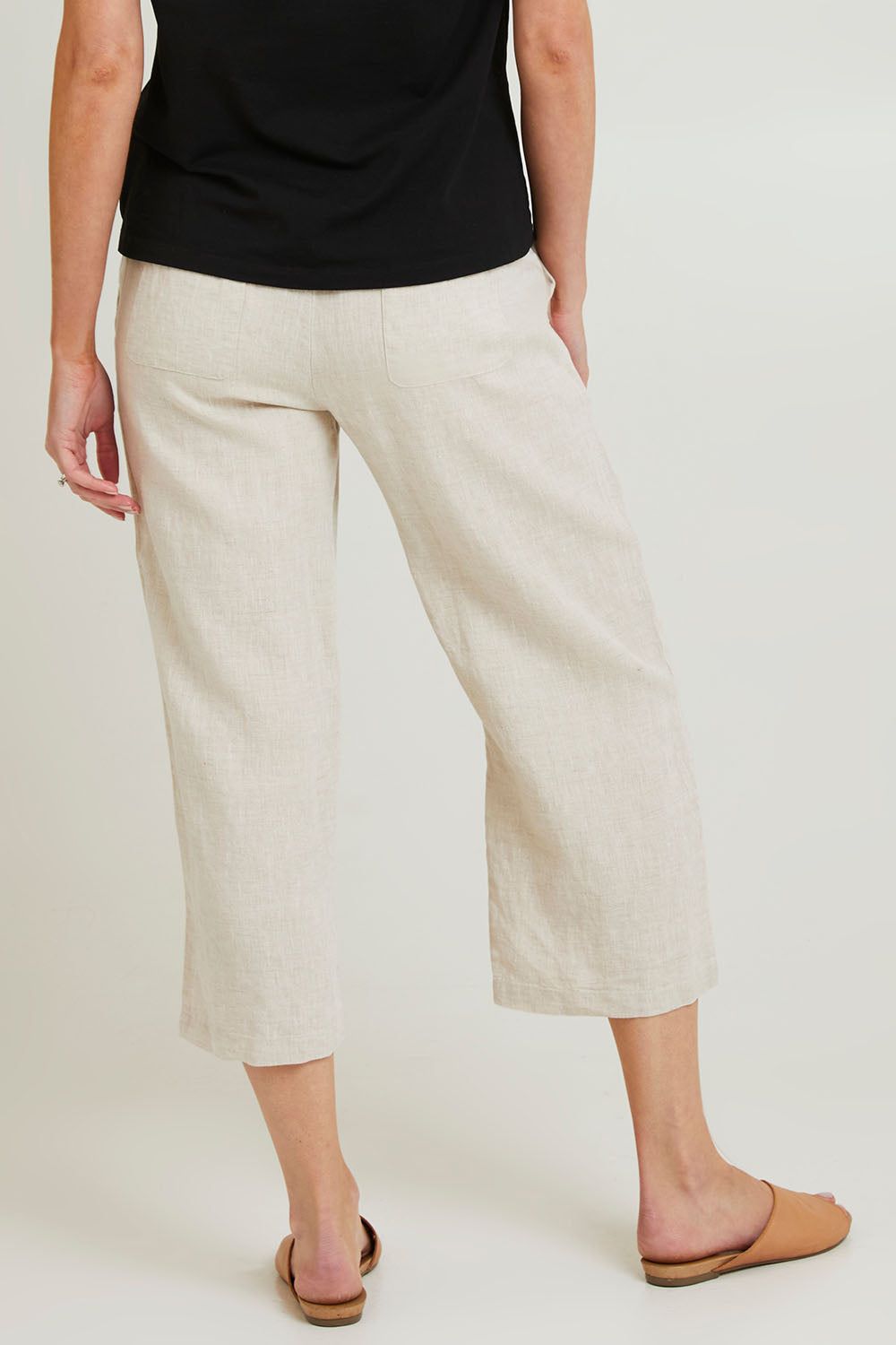 Model Grace wearing size 10 of the Classic Wide Leg Linen Pant in colour Natural, from the back