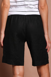 Model Madeline wearing size 10 of the Jersey Waist Linen Short in colour Black (Black), from the back