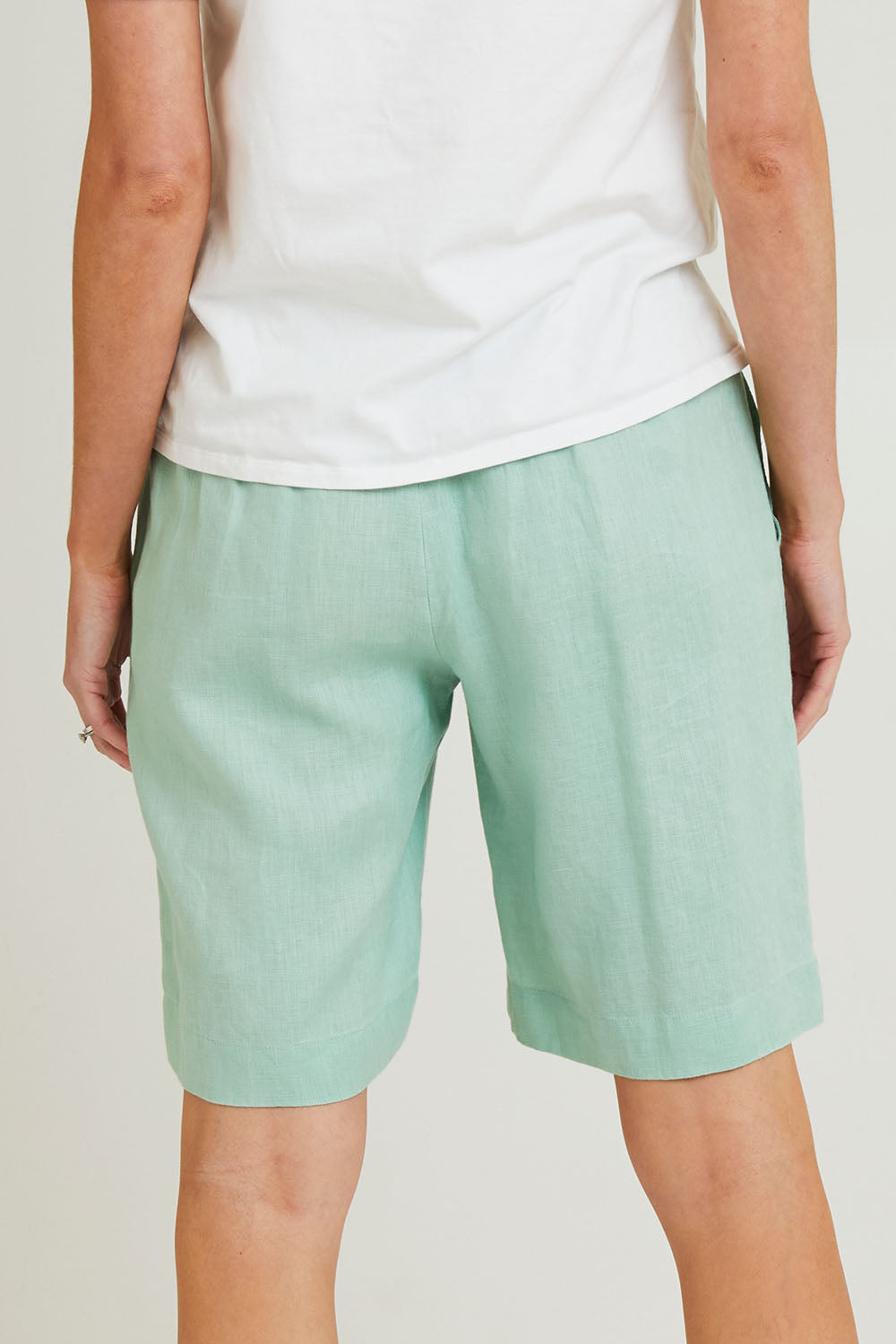 Model Grace wearing size 10 of the Jersey Waist Linen Short in colour Mint, from the back