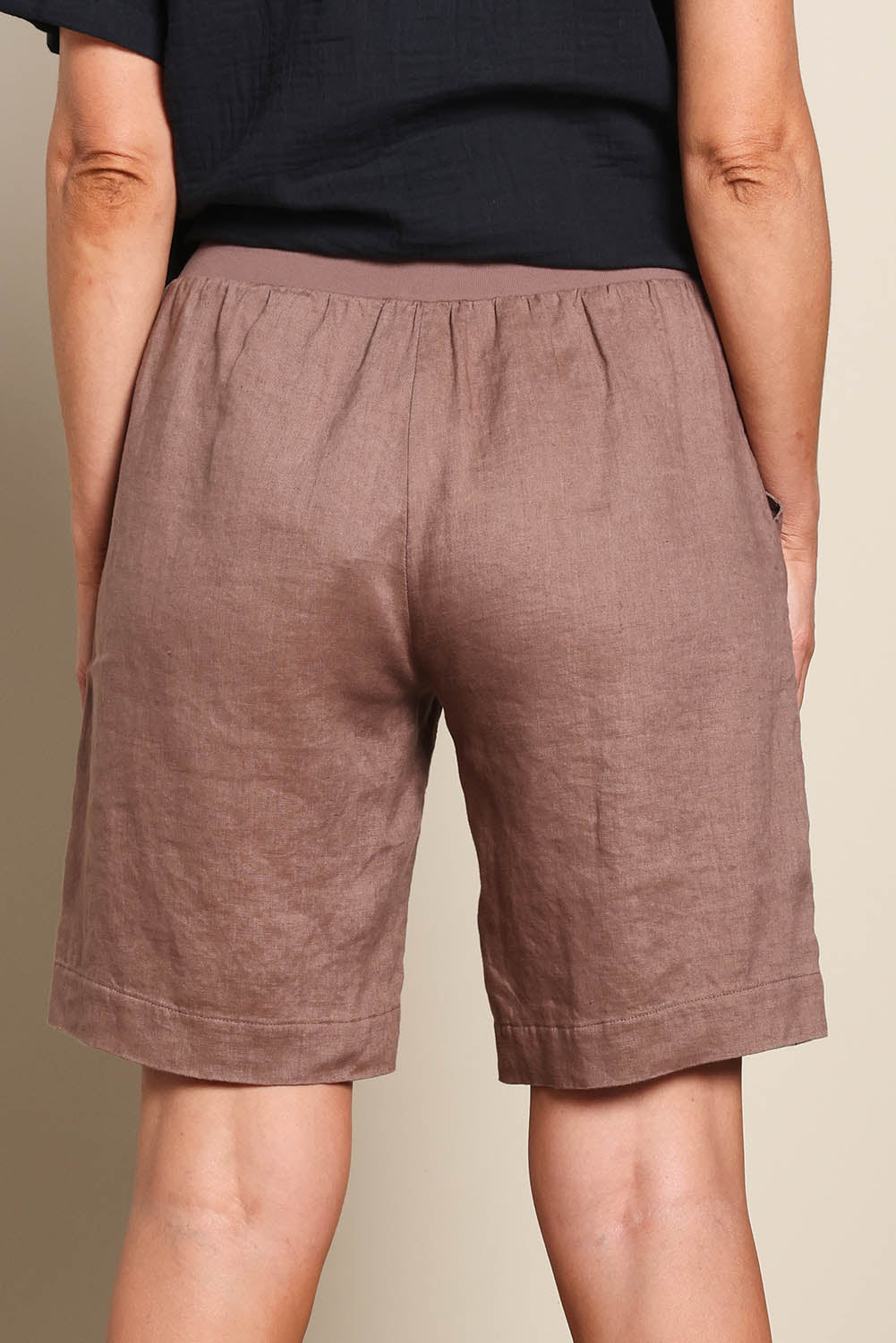Model Riinar wearing size 10 of the Jersey Waist Linen Short - Mocha in colour Mocha, from the back