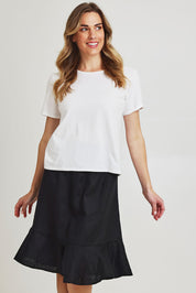 Model Olivia wearing size 10 of the Piccolo Linen Skirt in colour Black (Black), from the front, cropped image